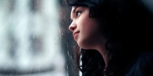 mujer con depresión por la ventana